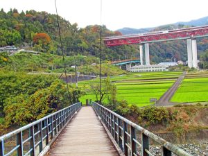 吊り橋を渡ると田園風景があり、前方に東名高速道路が見える